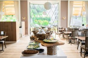 a dining room with a table with plates of food on it at Hotel Vejlefjord in Stouby