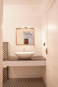 a bathroom with a white sink and a mirror at The Polaris in Cochin