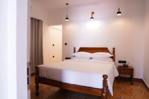 a bedroom with a large bed with white sheets and pillows at The Polaris in Cochin