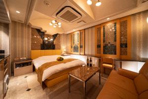 a bedroom with a bed and a couch and a table at Lucky Sun in Nishinomiya
