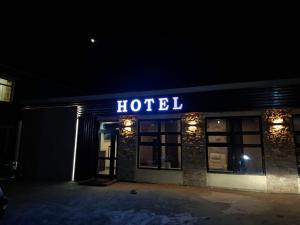a hotel building at night with a lit up sign at Khur motel in Dalandzadgad