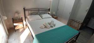 a bedroom with a bed with two towels on it at Villa Nikitas Beach in Agios Nikitas