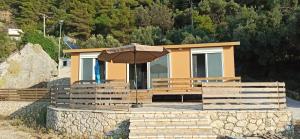a small house with an umbrella in front of it at Villa Nikitas Beach in Agios Nikitas