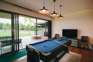a billiard room with a pool table and a television at Porsampao Luxury Villa in Ban Khok Khilek