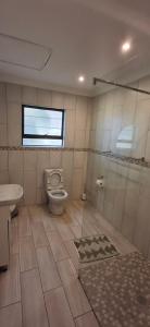 a bathroom with a toilet and a window at Villa Alba in Margate +13 photos