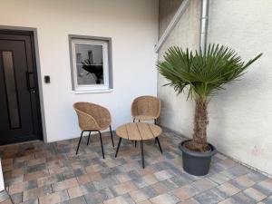 two chairs and a table and a potted plant at Zauberhafte Erdgeschoss-Maisonettewohnung in Bovenden