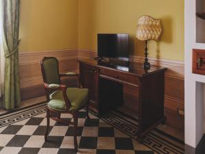 a room with a desk with a lamp and a chair at Hotel I Portici in Arezzo +29 photos