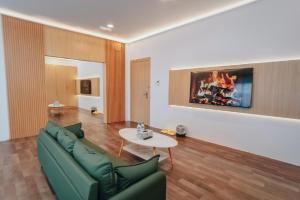 a living room with a green couch and a table at Hotel Koperasi in Seria