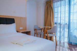 a bedroom with a bed and a table and chairs at Hotel Koperasi in Seria
