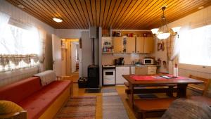 a living room with a table and a kitchen at Heidin Mummola Farm in Turtola +25 photos