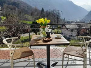 a table with a vase of flowers on a balcony at Casa Vacanza dei Nonni in Varzo