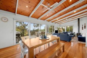 a living room with a wooden ceiling and a table at Salty Haven in Moggs Creek