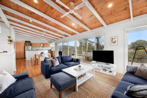 a living room with blue couches and a tv at Salty Haven in Moggs Creek