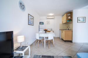 a kitchen and dining room with a table and chairs at Apartments Zoe in Bol