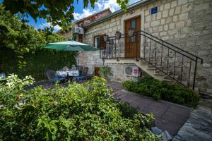 a patio with a table and an umbrella in front of a building at Apartments Zoe in Bol