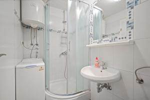 a white bathroom with a shower and a sink at Apartments Zoe in Bol +62 photos