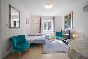 a bedroom with a bed and a chair and a television at Apartments Zoe in Bol