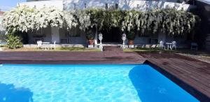a swimming pool in front of a house with trees at Phuket Nonnita Boutique Resort & Organic Farm in Phuket
