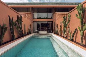 a swimming pool in front of a house at Cyrus Villa Seminyak by Ini Vie Hospitality in Seminyak