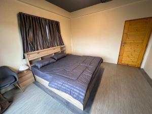 a bedroom with a bed and a wooden door at Hostel Friends Station & Cafe in Pattaya South