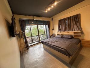 a bedroom with a bed and a large window at Hostel Friends Station & Cafe in Pattaya South +34 photos