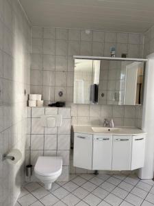 a white bathroom with a toilet and a sink at Ferienapartment Weimar Altstadt 1 in Weimar