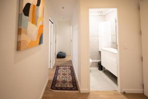 a hallway leading to a bathroom with a rug at Sky Two La Defense in Courbevoie