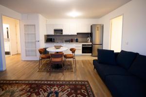a living room with a blue couch and a kitchen at Sky Two La Defense in Courbevoie +15 photos