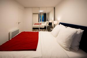 a bedroom with a large white bed with a red blanket at Sky Two La Defense in Courbevoie