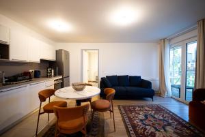 a living room with a table and a blue couch at Sky Two La Defense in Courbevoie