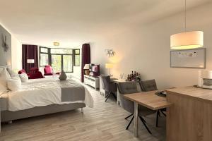 a bedroom with a bed and a table and chairs at Haus Roseneck mit gratis Zugang zur Jod-Sole-Therme in Bad Bevensen +45 photos