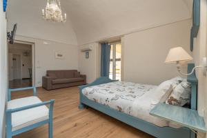 a bedroom with a bed and a chair and a couch at Terrazza Campailla in Modica