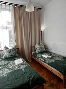 two beds sitting in a room with a window at Words & Swords in Krakow