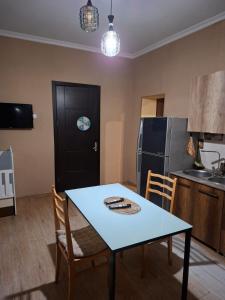 a kitchen with a table and chairs and a refrigerator at Onestep in Kutaisi +17 photos