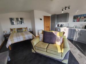 a living room with a couch and a bed at Bumble Bee Cabin in Bootle