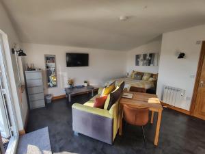 a living room with a couch and a bed at Bumble Bee Cabin in Bootle