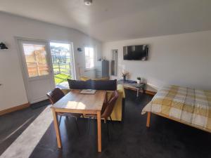 a room with a bed and a wooden table and chairs at Bumble Bee Cabin in Bootle