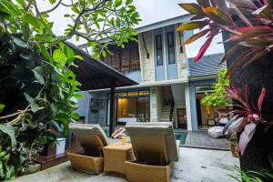 an external view of a villa with chairs and plants at La Paradis Villa in Canggu