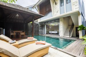 a villa with a swimming pool and a house at La Paradis Villa in Canggu