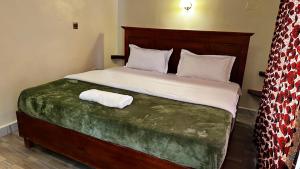 a bedroom with a large bed with a wooden headboard at Karibu Resort Sipi in Kapchorwa +13 photos