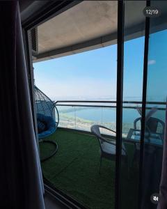 a balcony with chairs and a view of the ocean at Noida Stay with Yamuna View in Noida