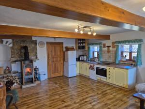 a kitchen with white appliances and a wooden floor at Chalupa Jestřebí in Velké Svatoňovice