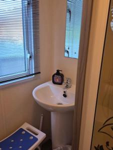 a bathroom with a sink and a clock on it at Luxury static caravan in Beattock +47 photos