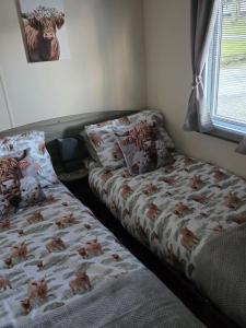 two beds sitting next to each other in a bedroom at Luxury static caravan in Beattock