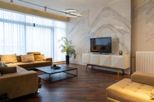 a living room with couches and a flat screen tv at Golden Palace Hotel in Tbilisi City