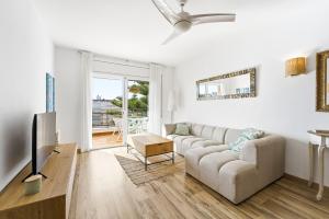 a living room with a couch and a tv at MY ALVA PARK - 50m from the beach in Lloret de Mar