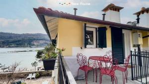 a house with red chairs and a table on a balcony at La Galleria del Tempo, Terre Marine in Portovenere