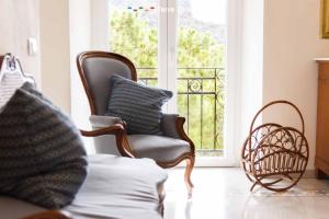 a living room with a chair and a balcony at La Galleria del Tempo, Terre Marine in Portovenere