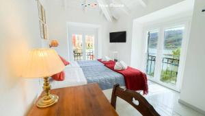 a bedroom with a bed and a table with a lamp at La Galleria del Tempo, Terre Marine in Portovenere