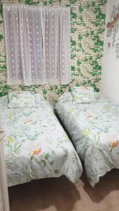 two beds sitting next to each other in a bedroom at Casita de Aldea in Sotrondio